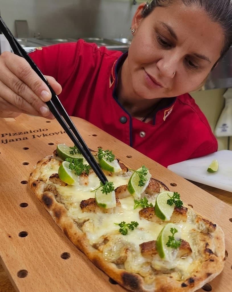 Dijana Ivković priprema pizzu in pala na dasci sa svojim imenom